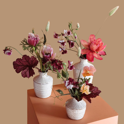 Trio of bud vase floral arrangements in ceramic vessels for event tables in Toronto