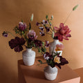 Three bud vase arrangements with seasonal flowers in ceramic vessels designed in Toronto